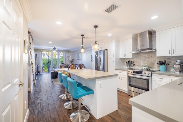 kitchen with white cabinetry, a center island, dark wood-type flooring, wall chimney range hood, and appliances with stainless steel finishes