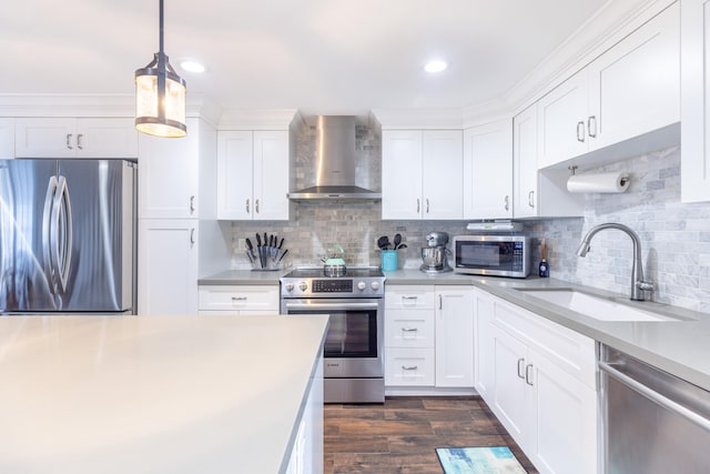 kitchen featuring white cabinets, wall chimney range hood, and appliances with stainless steel finishes