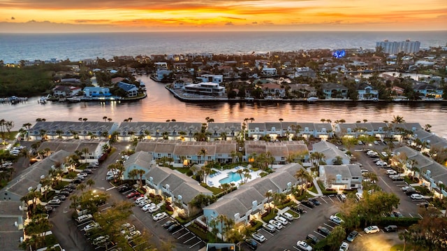 aerial view at dusk featuring a water view