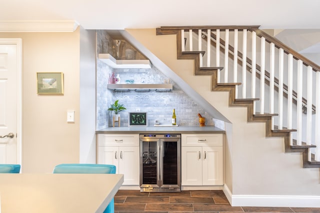 bar with backsplash, dark wood-type flooring, crown molding, white cabinets, and wine cooler