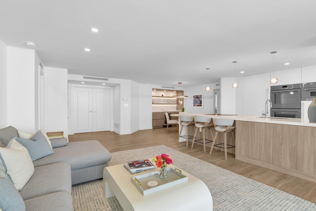 living room with sink and light hardwood / wood-style floors