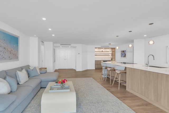 living room with sink and light hardwood / wood-style floors