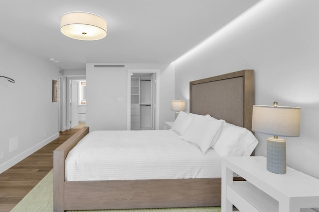 bedroom featuring a spacious closet, a closet, and dark hardwood / wood-style floors