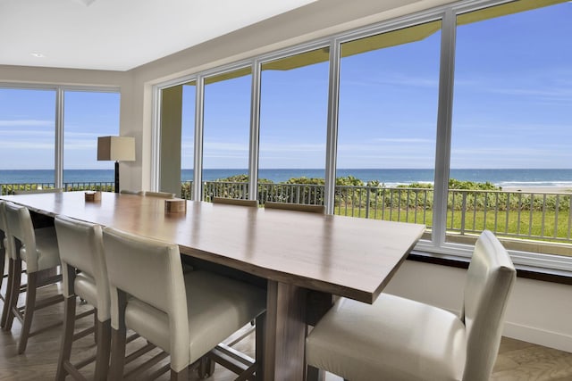 sunroom featuring a water view and a beach view