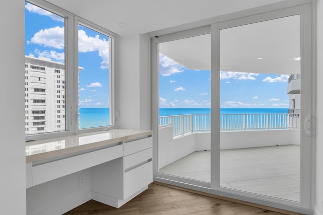 unfurnished sunroom featuring a water view