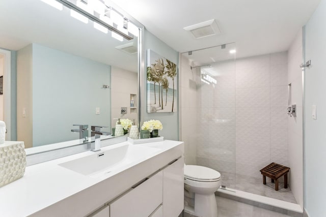 bathroom featuring vanity, an enclosed shower, and toilet