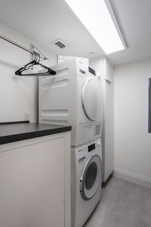 clothes washing area featuring stacked washer and clothes dryer