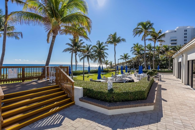 view of community featuring a deck with water view and a patio area