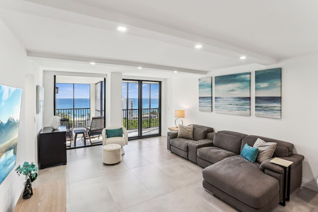 living room featuring light tile patterned flooring, a water view, and beam ceiling