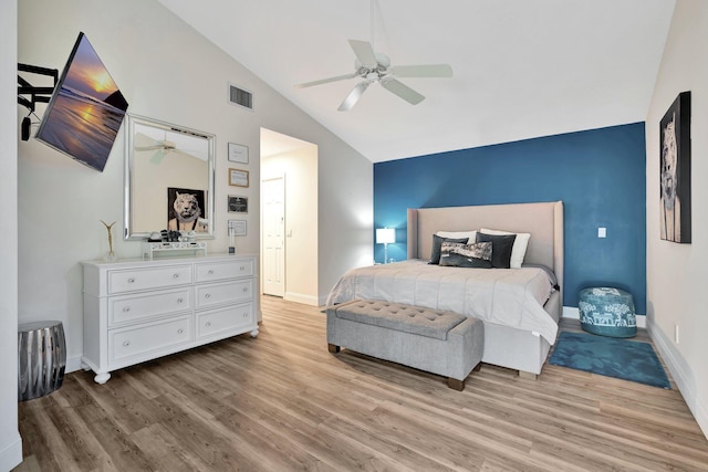 bedroom featuring light wood-type flooring, vaulted ceiling, and ceiling fan