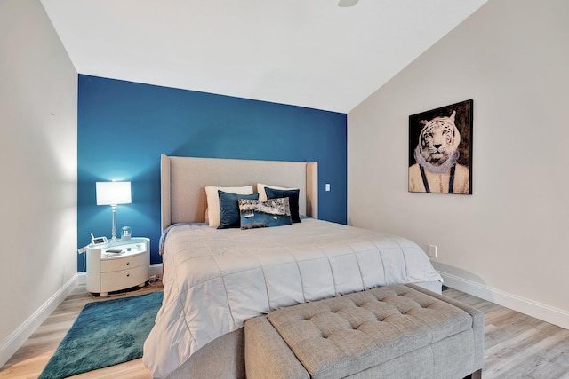 bedroom featuring lofted ceiling and light wood-type flooring