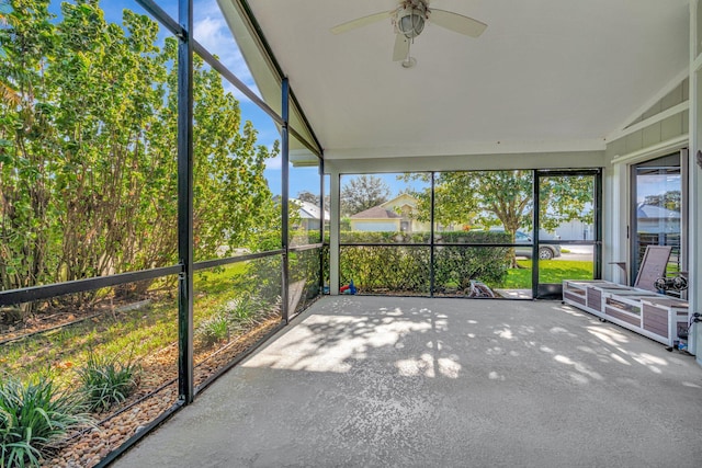 unfurnished sunroom with ceiling fan and vaulted ceiling