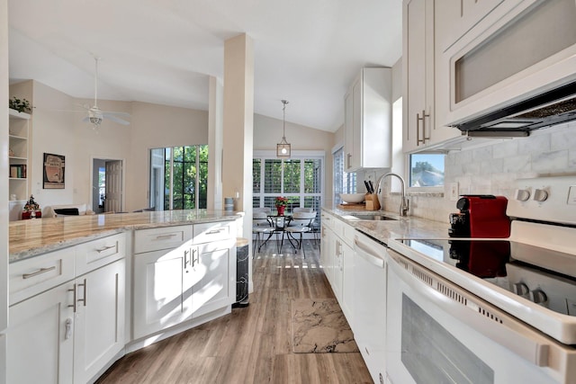 kitchen featuring lofted ceiling, white appliances, white cabinets, sink, and light hardwood / wood-style floors