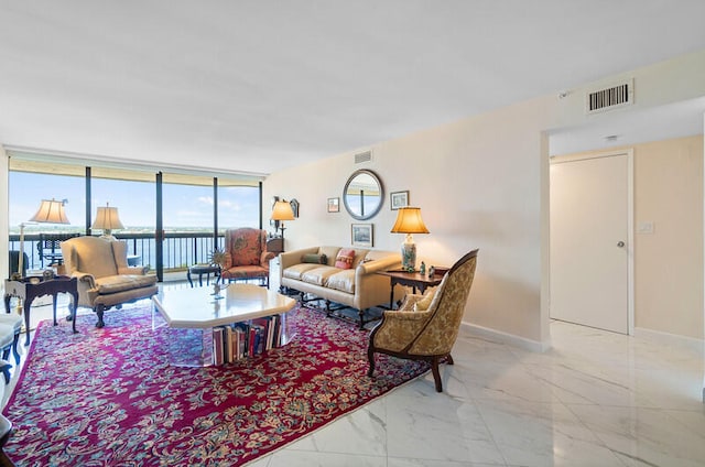 living room featuring floor to ceiling windows and a water view