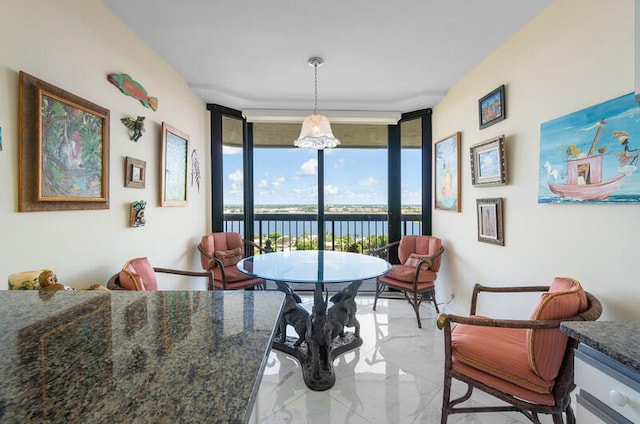 dining space with floor to ceiling windows and a water view