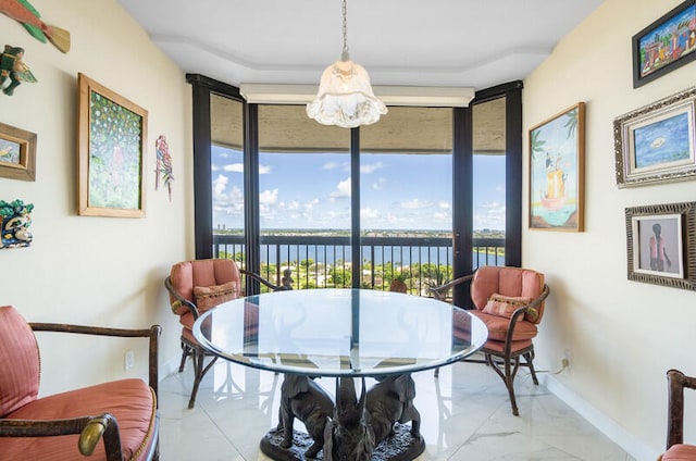 dining space with a water view and a wall of windows