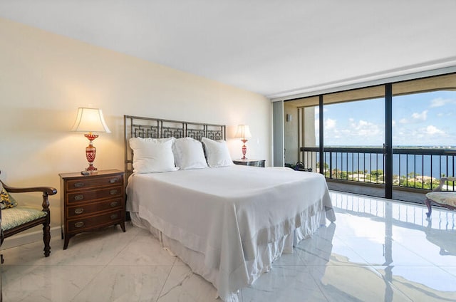 bedroom featuring floor to ceiling windows, a water view, and access to outside