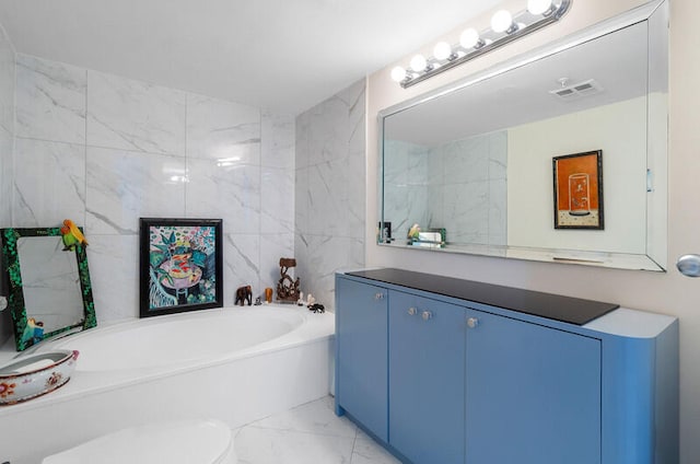 bathroom with a tub to relax in, vanity, and toilet