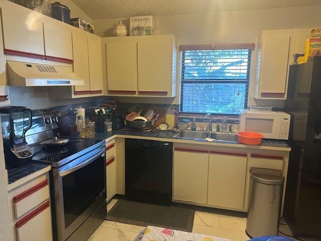 kitchen featuring refrigerator, tasteful backsplash, a textured ceiling, electric range, and dishwasher