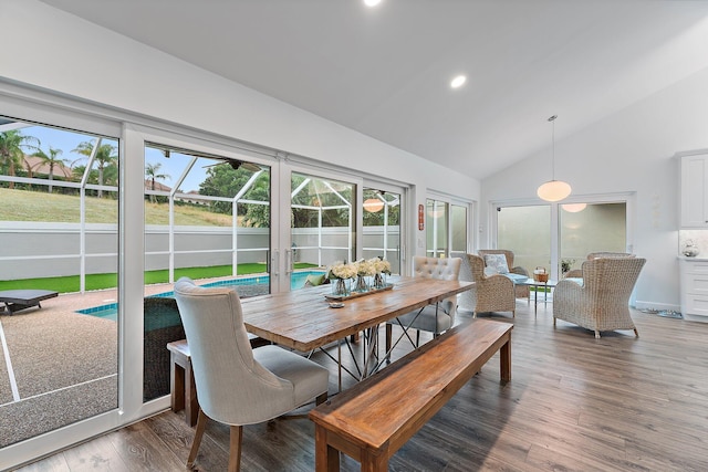 dining area featuring high vaulted ceiling and hardwood / wood-style flooring