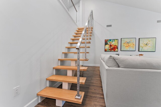 staircase featuring hardwood / wood-style floors and vaulted ceiling