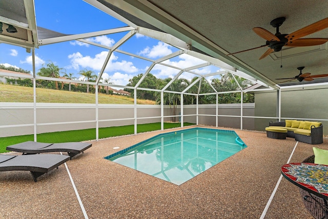 view of pool featuring glass enclosure, ceiling fan, and a patio area