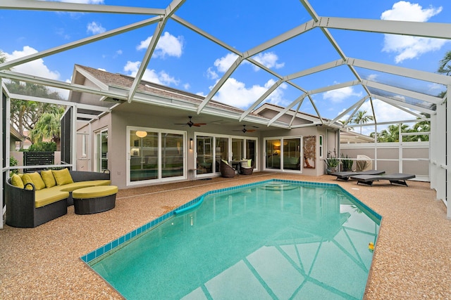 view of pool with outdoor lounge area, ceiling fan, a lanai, and a patio