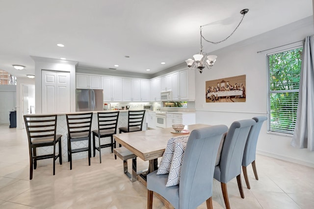 dining space with light tile patterned floors, crown molding, and a notable chandelier