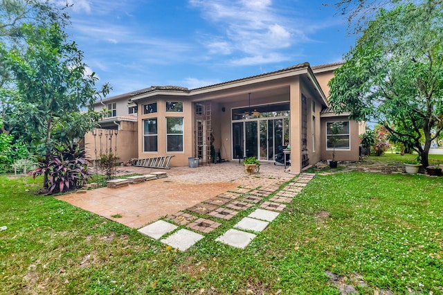 rear view of property featuring a yard and a patio area