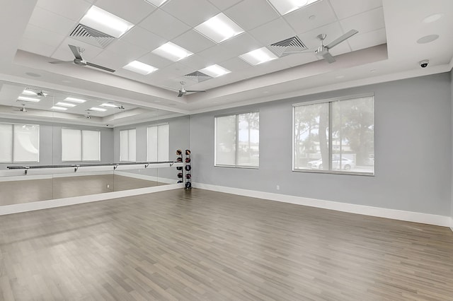 interior space featuring a drop ceiling, hardwood / wood-style flooring, a raised ceiling, and ceiling fan