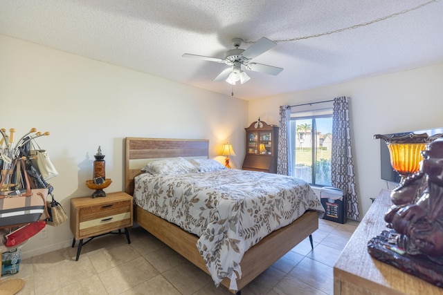 bedroom featuring ceiling fan, light tile patterned flooring, and a textured ceiling