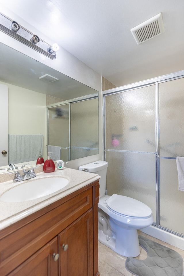 bathroom with toilet, vanity, tile patterned floors, and walk in shower