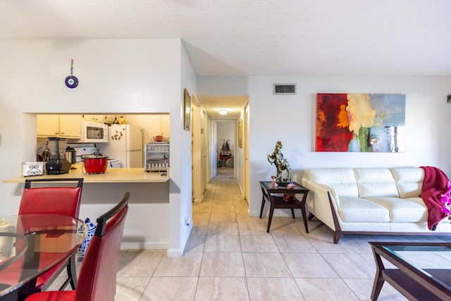 interior space with light tile patterned floors and a textured ceiling