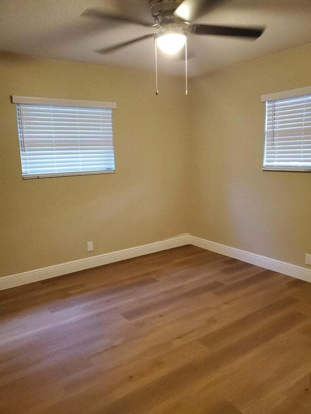 empty room featuring wood-type flooring and ceiling fan