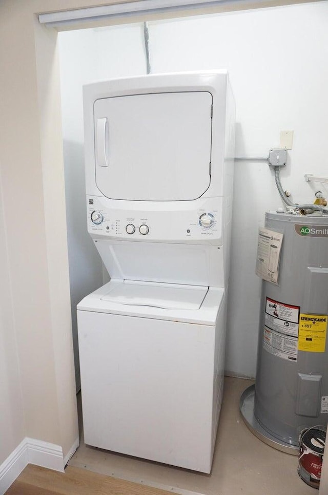 laundry area with light hardwood / wood-style flooring, stacked washer / dryer, and water heater