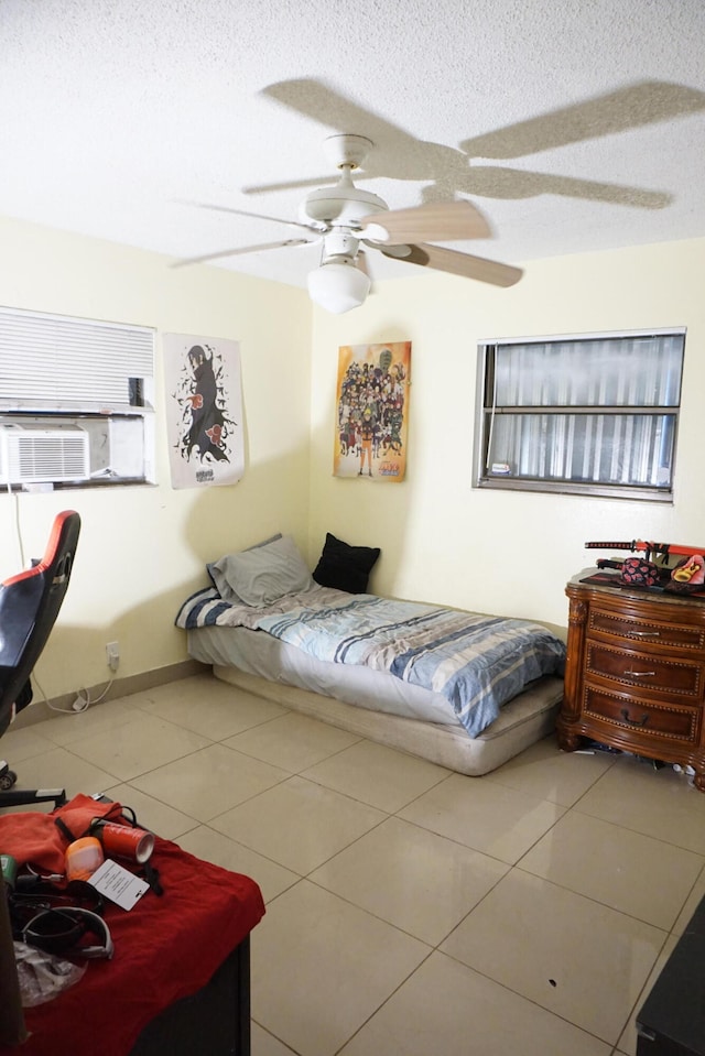 tiled bedroom with a textured ceiling and ceiling fan