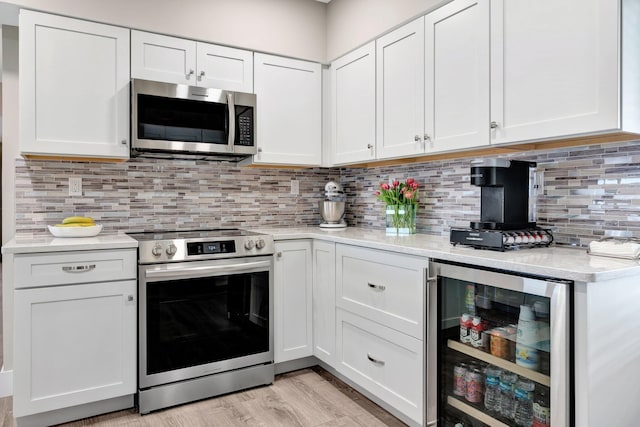 kitchen with white cabinets, stainless steel appliances, backsplash, and wine cooler