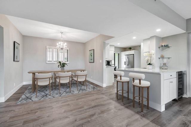 interior space featuring a notable chandelier, wine cooler, and hardwood / wood-style flooring