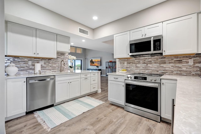 kitchen with appliances with stainless steel finishes, white cabinetry, and sink