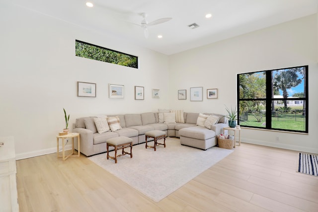 living room with ceiling fan and light hardwood / wood-style flooring