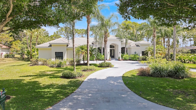 mediterranean / spanish house featuring a front lawn