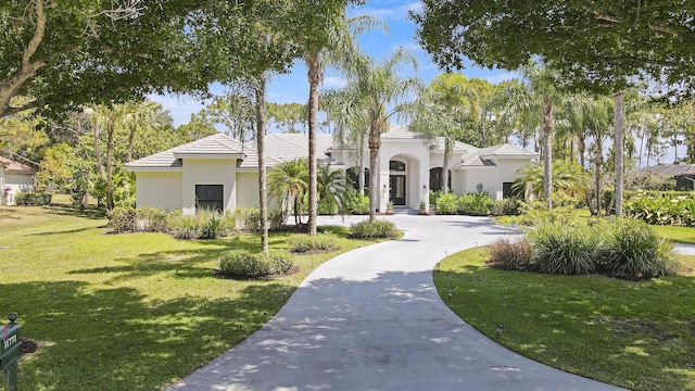 mediterranean / spanish-style home with a front yard