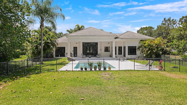 back of property featuring ceiling fan, a yard, a fenced in pool, and a patio area