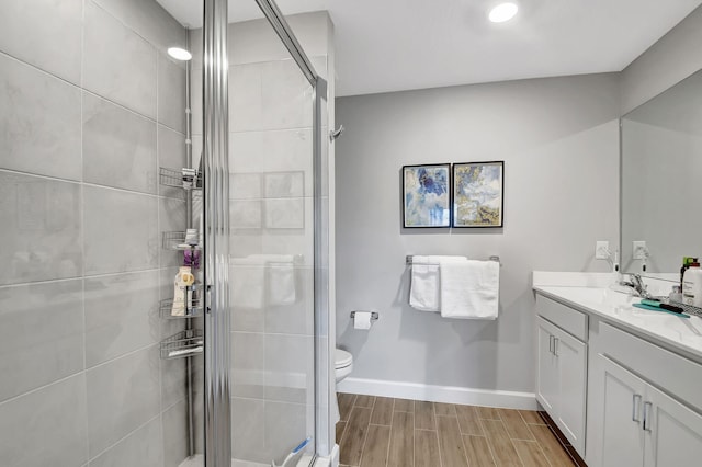 bathroom featuring walk in shower, vanity, and toilet