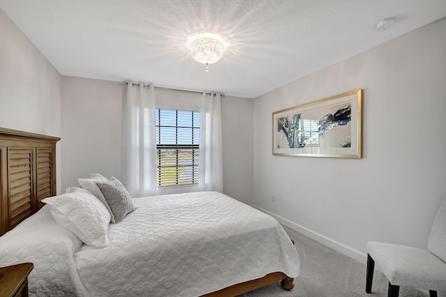 carpeted bedroom featuring a chandelier