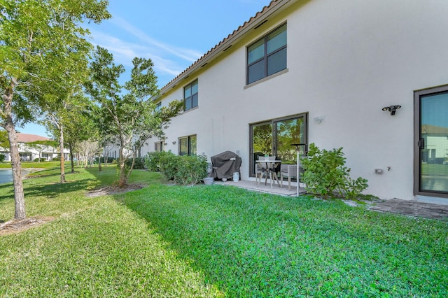 back of property with a patio area and a yard