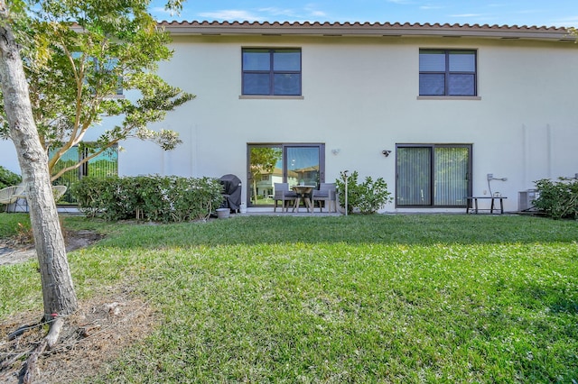 back of property featuring a lawn and cooling unit