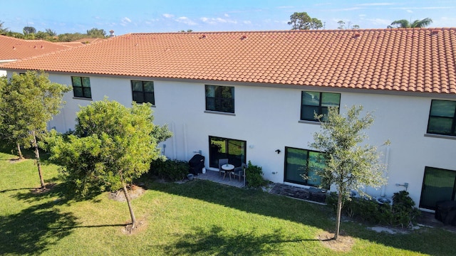 rear view of property featuring a patio area and a lawn