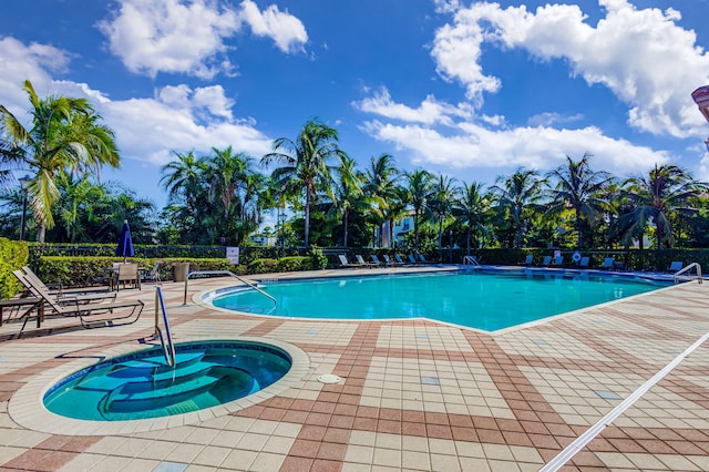 view of swimming pool featuring a patio and a hot tub