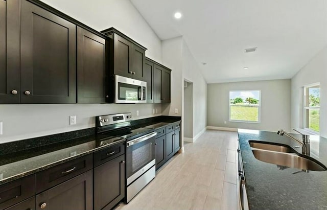 kitchen featuring plenty of natural light, sink, appliances with stainless steel finishes, and vaulted ceiling